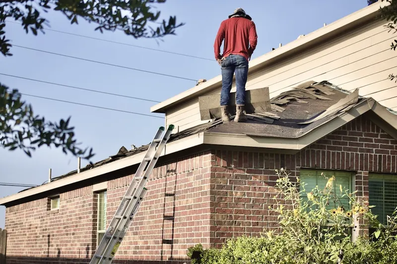 Professional roofer working on a residential roof in Gill